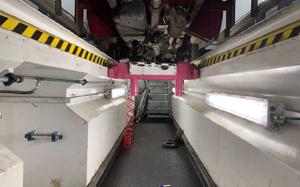 Photo of garage inspection pit equipped with a pit jack for thorough vehicle servicing, together with LED lighting