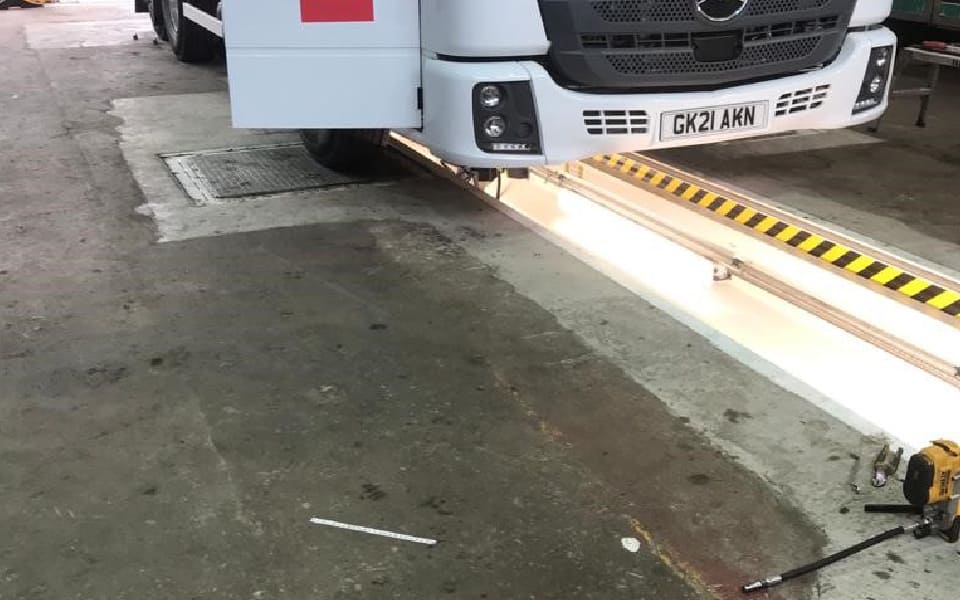 Commercial garage equipment installation for Biffa, Anglesey by CCS Garage Equipment, featuring recessed steel vehicle inspection pit with integrated safety lighting and hand rails