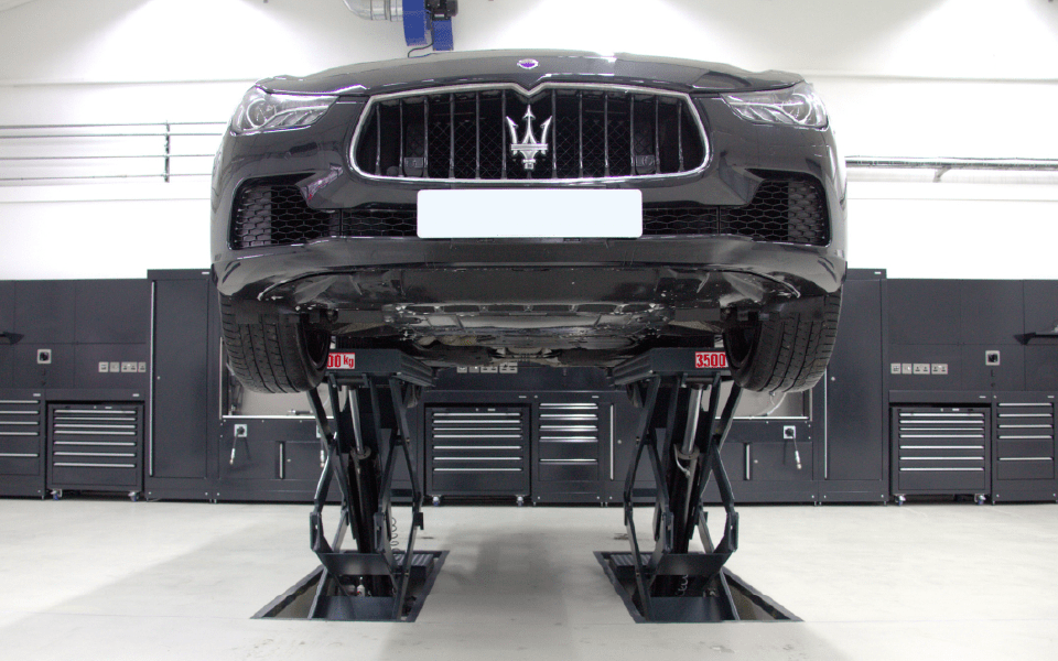 In-ground scissor vehicle lift installation at Charles Hurt Ferrari and Maserati dealership in Belfast, Northern Ireland
