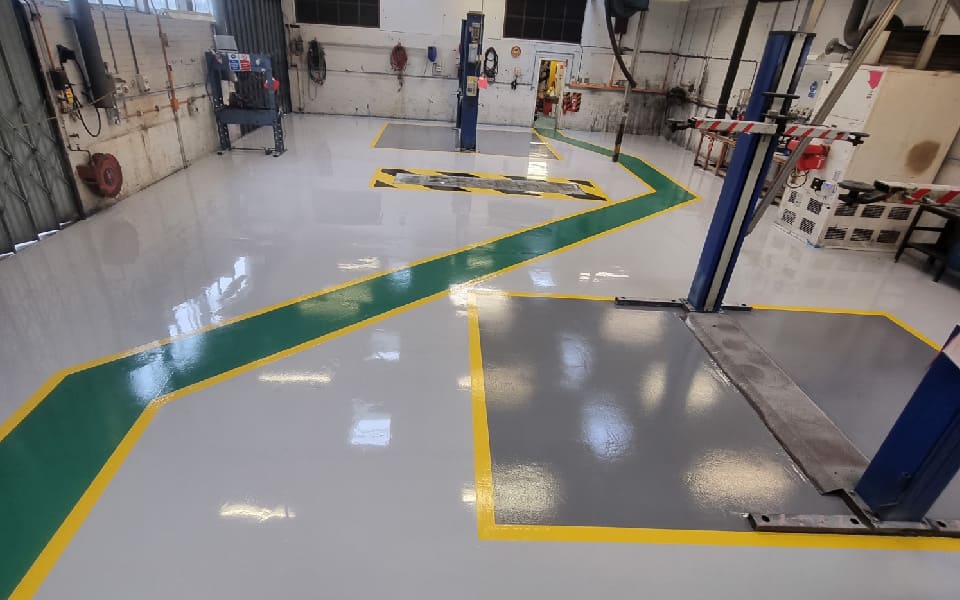 Anti-slip coating was applied to the epoxy resin floor paint in this workshop to create a hardwearing floor at East Midlands Airport by CCS Garage Equipment