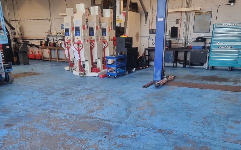 Flooring in poor condition prior to refurbishment works by CCS Garage Equipment at East Midlands Airport vehicle workshop