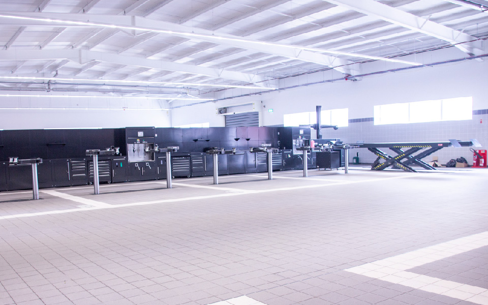 Unique workshop garage equipment installation featuring 2-post in-ground vehicle servicing lifts and scissor vehicle ramps installed at JLR Belfast by CCS Garage Equipment